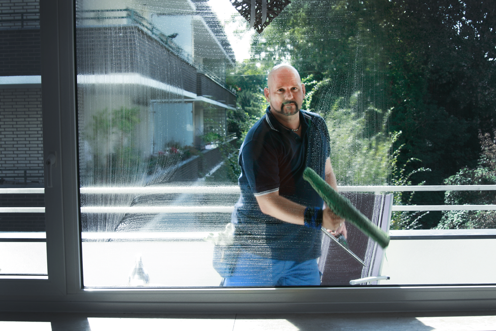 Unser Mitarbeiter bei sorgfältiger Glasreinigung